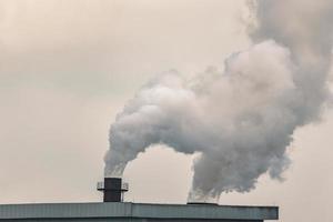 Emission von Rauch in die Luft aus Schornsteinen von Industrieanlagen foto