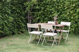 Holztisch mit Stühlen und Blumentopf im Garten im Hinterhof foto