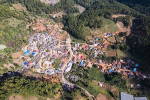 luftaufnahme des lokalen ländlichen dorfes im tal in der ferne auf dem land inmitten des tropischen regenwaldes foto