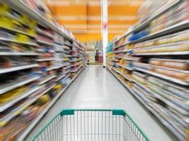 Einkaufswagen in der Gasse für Dessert- und Snackprodukte mit Werbeetikettenpreis im Supermarkt foto