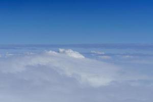 Naturansicht des blauen Himmels mit flauschiger weißer Wolke, die für Tapetenseite, Hintergrund oder Tapete verwendet wird foto