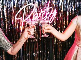 Zwei Hände reifer Frauen, die Sekt auf der Party trinken. feiertage, lebensereignis, feierkonzept foto