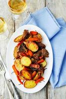Mit Kartoffeln, Karotten, Zwiebeln, Rosmarin und Knoblauch geröstetes Fleisch foto