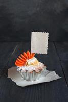 Cupcake mit leerem Etikett auf dem Holztisch