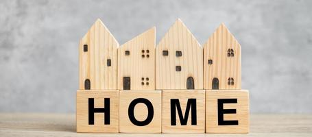 Holzblock mit Haustext und Hausmodell auf Holzhintergrund. bankwesen, immobilien, immobilieninvestitionen, immobilienhypotheken, finanz- und sparkonzepte foto