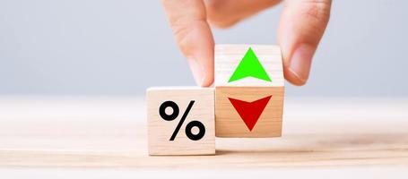 Geschäftsmann Hand ändern Holzwürfelblock mit Prozentsatz nach oben und unten Pfeilsymbol Symbol. Zinssatz, Aktien, Finanzen, Ranking, Hypothekenzinsen und Cut-Loss-Konzept foto