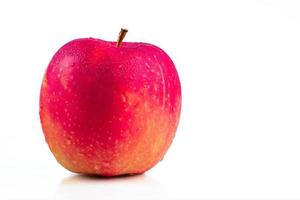 ein roter Apfel mit Wassertropfen auf der Haut isoliert auf weißem Hintergrund mit Kopierraum. gesundes obst und gesundes lebensmittelkonzept. veganes Essen.