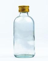leere transparente runde Glasflasche mit geschlossener gelber Aluminiumkappe isoliert auf weißem Hintergrund mit leerem Etikett und Kopierraum. Verwendung für Designvorlagen für Getränke- oder Medizinprodukte. foto