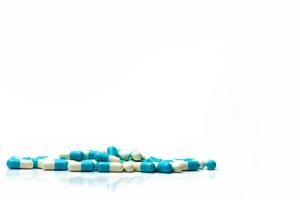 Haufen von blauen und weißen Kapseln Pillen isoliert auf weißem Hintergrund mit Schatten und Platz für Text kopieren. globales gesundheitskonzept. foto