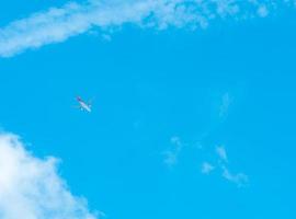 Flugzeug auf blauem Himmel und weißen Wolken. Verkehrsfluggesellschaft, die am blauen Himmel fliegt. Reiseflug für den Urlaub. Luftverkehr. mit dem Flugzeug in den Urlaub fahren. foto