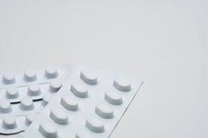 Makroaufnahme Detail der Tablettenpille in weißer Blisterpackung für lichtbeständige Verpackungen isoliert auf weißem Hintergrund. Medizin zur Behandlung ncds. Krankheit älterer Menschen. foto
