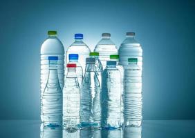 Set aus transparenter Plastikwasserflasche mit leerem Etikett. Flasche für klares Wasser und natürliche Mineralien mit weißem, grünem, rotem und blauem Verschluss. gesundes Getränk. sammlung von plastikflaschen mit voller flüssigkeit. foto