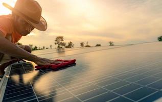 Mann reinigt Solarpanel auf dem Dach. Wartung von Solarmodulen oder Photovoltaikmodulen. nachhaltige ressourcen und erneuerbare energien für ein grünes konzept. Solarstrom für grüne Energie. Technologie für die Zukunft. foto