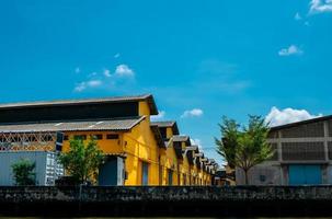 Lagergebäude im Vintage-Stil mit blauem Himmel und weißen Wolken. gelbes lager für die lagerung von waren. Außengebäude. Architektur im Vintage-Stil. Retro-Büro- und Lagergebäude aus Beton. foto