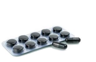 Kapseln und Tabletten Pillen aus Aktivkohle in Blisterpackung isoliert auf weißem Hintergrund foto