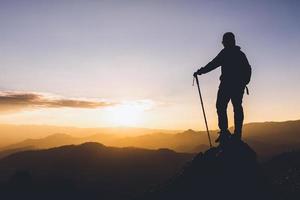 silhouette einer frau, die auf einem berg steht konzept der führung, des erfolgs, des wanderns. foto