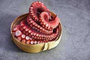 Gekochte Oktopus-Tentakel auf Holztablett, Oktopus-Essen gekochtes Meeresfrüchte-Tintenfisch-Abendessen-Restaurant foto