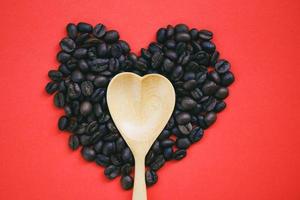 Herz Holzlöffel auf Herz Kaffeebohnen romantische Liebe Valentinstag auf rotem Hintergrund Liebeskaffeekonzept foto