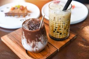 kakaogetränk schokolade und blasenmilchtee oder taiwan-milchtee im glas auf dem holztisch mit kuchen foto