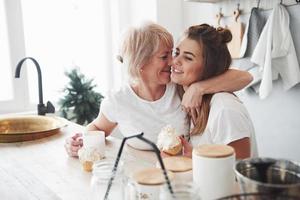 Sie wird immer ein Kind für sie sein. Mutter und Tochter amüsieren sich in der Küche foto