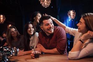 Mädchen grüßt einen Freund. Schöne Jugendliche feiern zusammen mit Alkohol im Nachtclub foto