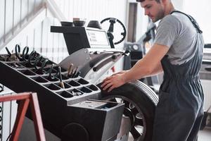 jedes Werkzeug, das Sie brauchen. junger mann arbeitet tagsüber mit radscheiben in der werkstatt foto