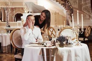 oh komm schon, ich weiß, du bist es. Schönes Paar hat abends ein romantisches Abendessen im Luxusrestaurant foto