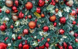 nahaufnahme weihnachtsbaumschmuck mit roter kugel, goldener kugel, goldener schneeflocke, rotem stern. Weihnachtshintergrund. weihnachten und frohes neues jahr urlaub hintergrund. foto
