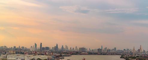 stadtbild des modernen gebäudes. Stadtbild in Asien. Geschäftsgebäude. Stadt mit Sonnenuntergangshimmel. Horizontale Ansicht der Stadt mit einer Menge von Wolkenkratzern und dem Fluss. Hauptstadt in Thailand. foto