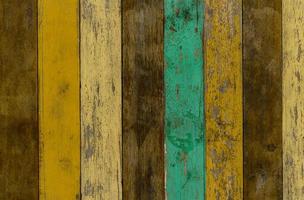 gelber, grüner und brauner hölzerner wandbeschaffenheitshintergrund. alter holzboden mit rissiger farbfarbe. Vintage Holz abstrakten Hintergrund mit abblätternder Farbe. grün und gelb auf brauner Holzstruktur gemalt.