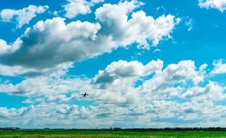 kommerzielle fluggesellschaft, die auf blauem himmel und weißen flauschigen wolken fliegt. Passagierflugzeug nach dem Start oder zum Landeflug. Urlaubsreisen ins Ausland. Lufttransport. Bereich rund um den Flughafen. foto