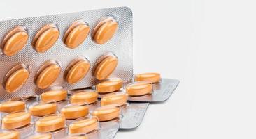 orangefarbene ovale Tablettenpillen in Blisterpackung auf weißem Hintergrund. Arzneimittel zur Behandlung von venösen Durchblutungsstörungen und Hämorrhoiden und akuten Hämorrhoidenanfällen. Pharmaindustrie. Pharmazie. foto