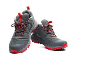 Männer Trekkingschuhe isoliert auf weißem Hintergrund. grau-rote wanderschuhe. Sicherheitsschuhe zum Klettern. Abenteuerausrüstung. leichte Trekkingschuhe aus Gummi mit Sicherheitssohle. modernes und atmungsaktives Design. foto