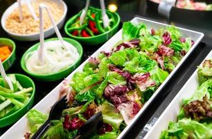 Salatbuffet im Restaurant. frisches Salatbuffet zum Mittag- oder Abendessen. gesundes Essen. frischer grüner und violetter Salat in weißer Platte auf der Theke. Catering-Essen. Bankettservice. vegetarisches Essen.