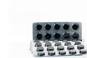 Aktivkohletabletten Pillen in Blisterpackung isoliert auf weißem Hintergrund mit Kopierplatz für Text. Schwarze runde Pillen zur Behandlung von Vergiftungen durch Überdosierung von Medikamenten foto
