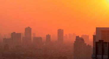 Luftverschmutzung in Bangkok, Thailand. smog und feinstaub der pm2.5 bedeckten stadt morgens mit orangefarbenem sonnenaufgangshimmel. stadtbild mit verschmutzter luft. schmutzige Umgebung. städtischer giftiger Staub. ungesunde Luft. foto