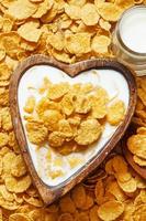 gesundes Frühstück: Cornflakes mit Milch in einer Holzschale