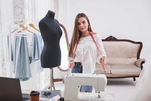Modedesignerin arbeitet in der Werkstatt an den neuen Kleidern foto