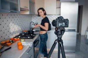 Fokus auf die Kamera. Mädchen in der modernen Küche zu Hause zu ihrer Wochenendzeit am Morgen foto