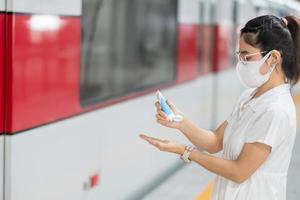 Frau saubere Hand mit Alkohol-Gel-Desinfektionsmittel im Zug oder in öffentlichen Verkehrsmitteln, Infektion mit Coronavirus-Krankheit. persönliche hygiene, sicherheit und reisetransport unter covid-19-konzepten foto