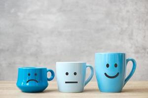 Emotionsgesicht der blauen Kaffeetasse. zur Kundenrezension. Servicebewertung, Ranking, Zufriedenheit, Bewertung und Feedback-Konzept. Welttag des Lächelns und Internationaler Kaffeetag foto