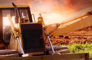 Selektiver Fokus auf Bulldozer auf unscharfem Hintergrund eines Baggerladers auf der Baustelle. Aushubfahrzeug. hydraulischer Arm. Landentwicklungsgeschäft. Planierraupe zu vermieten. Maschine in der Bauindustrie. foto