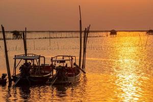 schöner sonnenuntergang über dem meer. dunkler und goldener sonnenunterganghimmel und wolken. Naturhintergrund für ein ruhiges und friedliches Konzept. Sonnenuntergang in Chonburi, Thailand. Kunstbild des Himmels in der Abenddämmerung. Landwirtschaft im Meer. foto