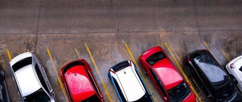 Blick von oben auf das Auto, das auf einem Betonparkplatz mit gelber Verkehrszeichenlinie auf der Straße geparkt ist. oben Ansicht des Autos in einer Reihe am Parkplatz. kein verfügbarer Parkplatz. Außenparkplatz. foto