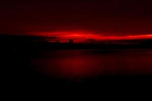 roter und orangefarbener sonnenuntergangshimmel am berg und am see. schöner Abendhimmel. majestätischer Sonnenuntergangshimmel. Naturhintergrund. Kunstbild des Himmels in der Abenddämmerung. abstrakter hintergrund des sonnenuntergangs. Dämmerungs- und Dämmerungskonzept foto