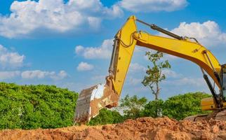 baggerarbeiten durch graben von boden auf der baustelle. Eimer Bagger graben Erde. Raupenbagger, der auf dem Boden gräbt. Aushubmaschine. Erdbewegungsmaschine. Aushubfahrzeug. foto