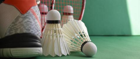 Badminton-Sportgeräte auf grünem Boden von Badminton-Federbällen, Schlägern, Schuhen, selektiver Fokus auf Federbälle, Badminton-Sportliebhaber auf der ganzen Welt. foto