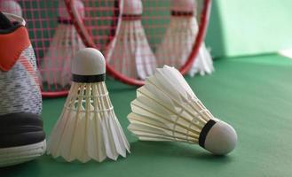 Badminton-Sportgeräte auf grünem Boden von Badminton-Federbällen, Schlägern, Schuhen, selektiver Fokus auf Federbälle, Badminton-Sportliebhaber auf der ganzen Welt. foto