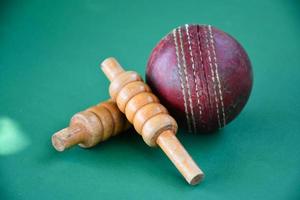 Nahaufnahme alter Cricket-Sportgeräte auf grünem Boden, alter Lederball und hölzerne Pforten, weicher und selektiver Fokus, traditionelle Cricket-Sportliebhaber auf der ganzen Welt Konzept. foto