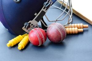 alte trainings-cricket-sportgeräte auf dunklem boden, lederball, wickets, helm und holzschläger, weicher und selektiver fokus, traditionelle cricket-sportliebhaber auf der ganzen welt. foto